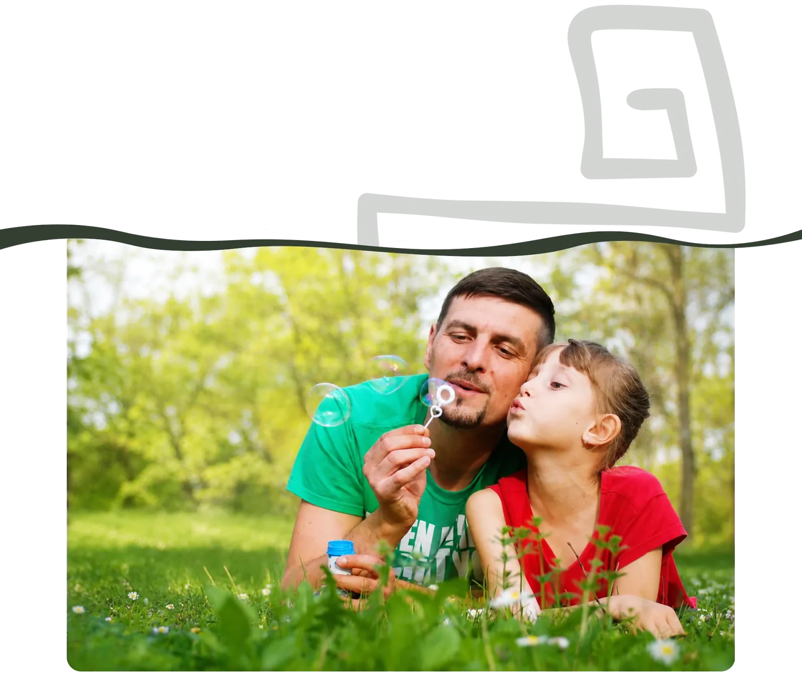 Un père et sa fille font des bulles dans l'herbe